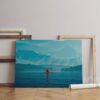 Woman kayaking into a lake with mountains Canvas Wall Art