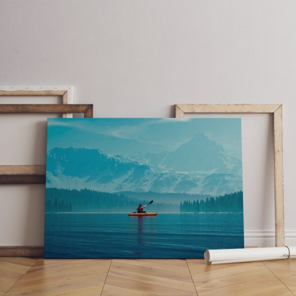 Woman kayaking into a lake with mountains Canvas Wall Art