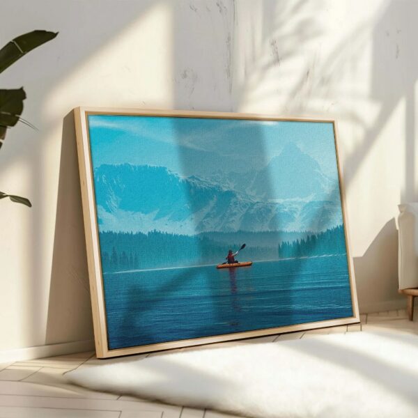 Woman kayaking into a lake with mountains Canvas Wall Art